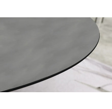 Nahaufnahme einer abgerundeten Tischkante aus dunklem Glas oder Keramik.