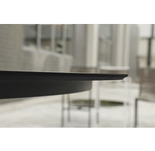 Nahaufnahme der schmalen schwarzen Tischkante eines Gartentischs im Außenbereich.