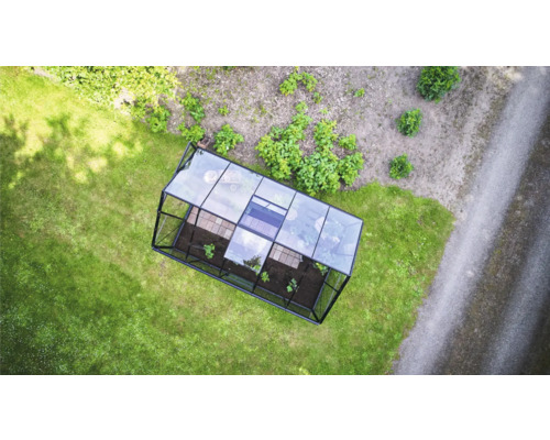 Draufsicht auf ein rechteckiges Gewächshaus mit Metallrahmen und Glaspaneelen auf einer Rasenfläche im Garten.