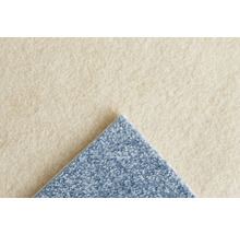 Nahaufnahme eines beigen und blauen Teppichbodens mit weicher, strukturierter Oberfläche und sichtbarem Flor.