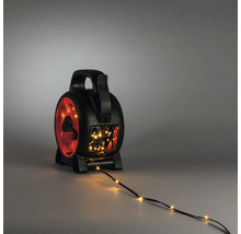 Schwarze und rote Kabeltrommel für Lichterketten aus Kunststoff mit Tragegriff, Kurbel und warmweißer LED-Lichterkette.