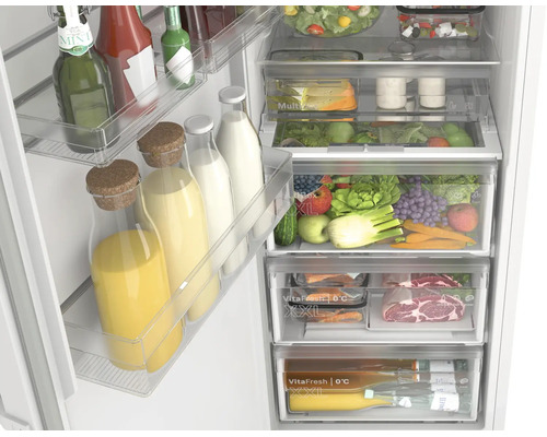 Blick in einen gut organisierten Kühlschrank mit VitaFresh Schubladen, Obst, Gemüse, Fleisch und Flaschen auf den Türabstellern.