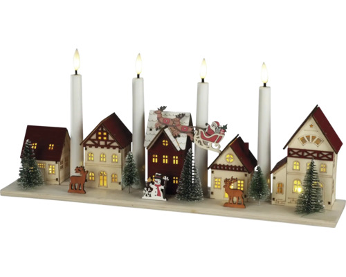 LED-Weihnachtsleuchter aus Holz mit beleuchteter Häuserszene, Tannenbäumen, Rentieren und vier LED-Stabkerzen.