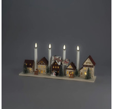 Weihnachtsdekoration aus Holz mit Miniaturdorf, beleuchteten Häusern, Tannenbäumen, Rentieren und vier weißen elektrischen Kerzen auf Holzsockel.