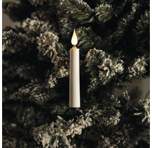 LED-Christbaumkerze an einem verschneiten Tannenbaumzweig mit warmweißem Licht.
