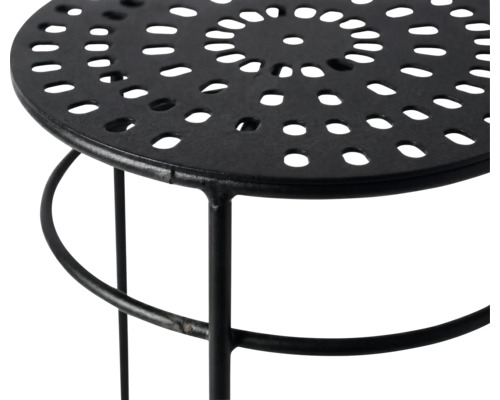 Metallhocker mit runder perforierter Platte und schwarzem Gestell.