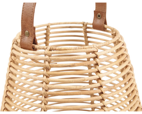 Nahaufnahme einer geflochtenen Laterne aus Rattan mit einem Tragegriff aus Leder und Metallnieten.