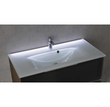 Glaswaschtisch mit integrierter LED-Beleuchtung, verchromter Armatur und dunklem Waschtischunterschrank.