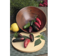 Frische Jalapeño-Paprikas in verschiedenen Reifestadien in einer Holzschale und auf einem Holzbrett neben einer Zitrone.