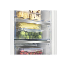 Gefrierschrank mit übersichtlich organisierten Lebensmitteln in transparenten Schubladen wie Rosenkohl und Erdbeeren.