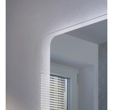 Detailaufnahme eines Badezimmerspiegels mit integrierter LED-Beleuchtung und abgerundeten Ecken.