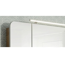 Spiegelschrank mit LED-Aufsatzleuchte und Korpus in Holzoptik.