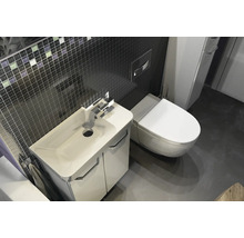Modernes Badezimmer mit weißem Waschtischunterschrank, Keramikwaschbecken, wandhängendem WC und dunkler Mosaikfliesenwand.