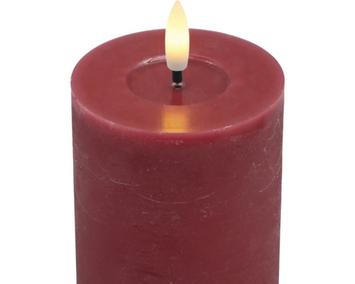 Rote LED-Stumpenkerze mit rustikaler Oberfläche und warmweißer LED-Flamme.