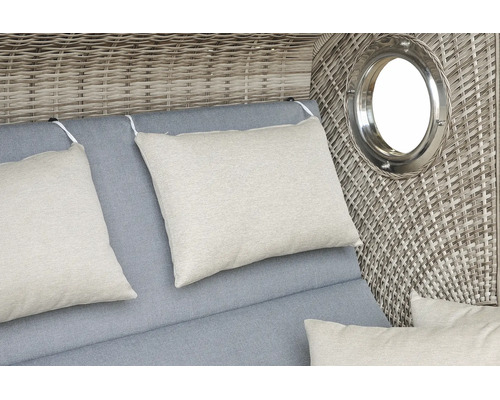 Detailansicht Strandkorb mit grauer Rückenpolsterung, beige Dekokissen und integriertem Bullauge im Geflecht.