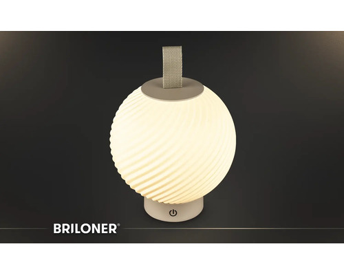 Briloner tragbare LED-Tischleuchte in Kugelform mit gerippter Oberfläche, Trageschlaufe und Touch-Schalter am Sockel. Briloner Logo.