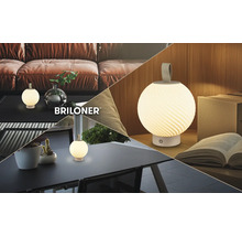 Briloner tragbare LED-Tischleuchte mit kugelförmigem strukturiertem Schirm, abgebildet auf einem Couchtisch, einem Gartentisch und einem Schreibtisch.