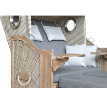 Strandkorb aus Geflecht und Holz mit Bullaugen, Klapptischen und Polstern.