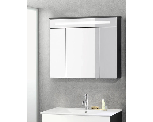 Dreitüriger Spiegelschrank mit LED-Beleuchtung über einem weißen Waschtisch mit verchromter Armatur in einem modernen Badezimmer.