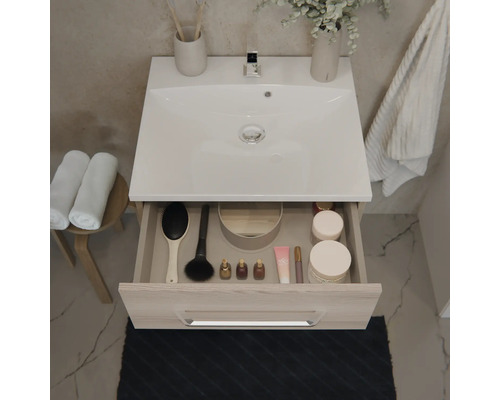Moderner Waschbeckenunterschrank mit weißem Waschbecken und offener Schublade inklusive Organizer für Badutensilien.