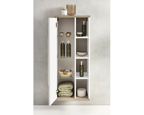 Schmaler Badezimmer-Hängeschrank mit einer Tür und offenen Regalfächern, ausgestattet mit Glaseinlegeböden, Badutensilien und Handtüchern.