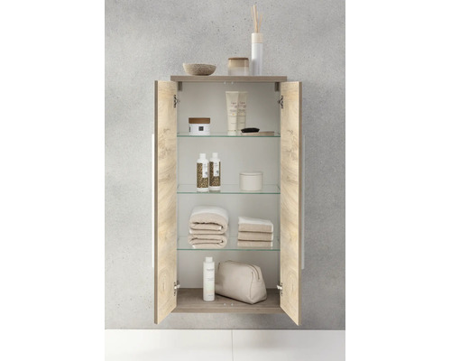 Offener Badezimmer-Wandschrank in Holzoptik mit Glaseinlegeböden, befüllt mit Pflegeprodukten und Handtüchern.