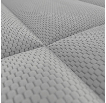 Nahaufnahme einer gepolsterten Stoffoberfläche mit quadratischer Textur.