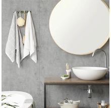 Modernes Badezimmer mit rundem Spiegel, weißem Aufsatzwaschbecken auf Holztisch und grauen Wandpaneelen in Betonoptik.