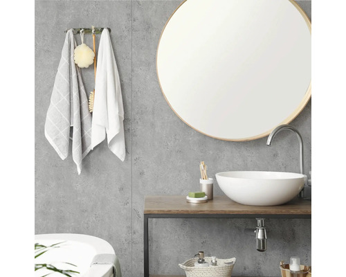 Modernes Badezimmer mit rundem Spiegel, weißem Aufsatzwaschbecken auf Holztisch und grauen Wandpaneelen in Betonoptik.