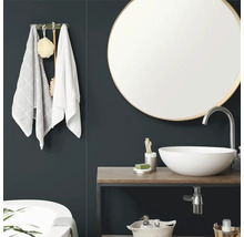 Modernes Badezimmer mit rundem Wandspiegel, weiem Aufsatzwaschbecken auf einer Holzplatte und Handtuchhalter.