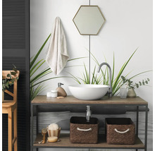Modernes Badezimmer mit rundem Aufsatzwaschbecken auf einem Holzwaschtisch, hoher Armatur, hexagonalem Spiegel und geflochtenen Aufbewahrungskörben.