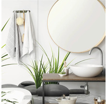 Modernes Badezimmer mit rundem Spiegel, weißem Aufsatzwaschbecken auf einem Holzwaschtisch und einer Glaswand mit Gras- und Steinmotiven.