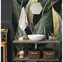Fototapete mit großen botanischen Blättern im Badezimmer hinter einem Waschtisch aus Holz mit weißem Aufsatzwaschbecken und Zubehör.