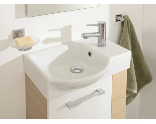 Modernes Badezimmer mit kompaktem Waschplatz, weißem Keramikwaschbecken, Holzoptik-Unterschrank, Seifenschale und Handtuchhalter.