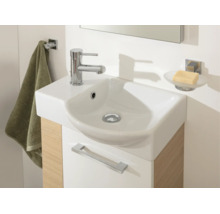 Modernes kleines Waschbecken mit verchromter Armatur auf einem Waschtischunterschrank in Holzoptik mit Handtuchhalter und Seifenschale.