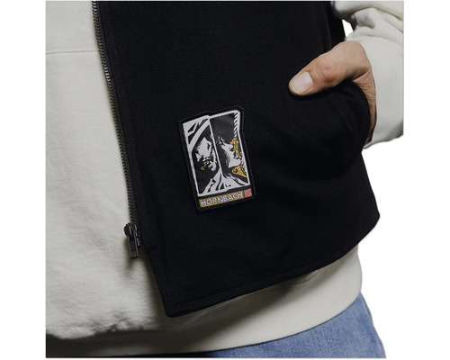 Schwarze Weste mit Reißverschluss, Hornbach Logo und Tasche über einem hellen Hoodie.