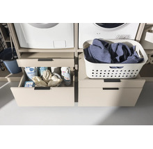 Wäscheschrank-Podest mit Schubladen unter Waschmaschine und Trockner, links geöffnet mit Waschmitteln, rechts geschlossen mit Wäschekorb.