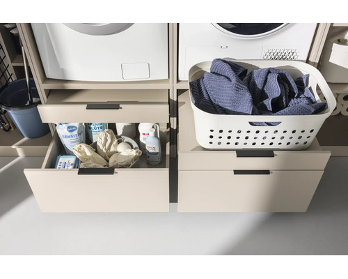 Wäscheschrank-Podest mit Schubladen unter Waschmaschine und Trockner, links geöffnet mit Waschmitteln, rechts geschlossen mit Wäschekorb.
