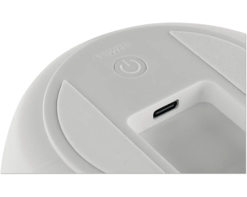 Detailansicht eines runden Power-Buttons und eines USB-C-Ladeanschlusses an einem elektronischen Gerät.