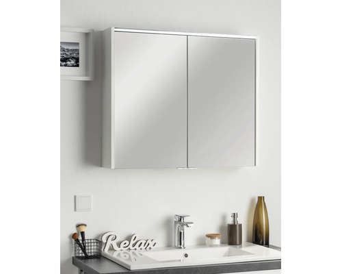 Spiegelschrank mit zwei Türen in einem modernen Badezimmer über einem Waschbecken mit Armatur und Dekoration.
