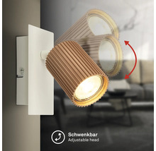 Wandleuchte mit schwenkbarem, geriffeltem Strahlerkopf in Holzoptik und weißer Wandhalterung.