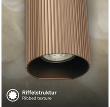 Detailansicht einer zylindrischen Leuchte mit geriffelter Oberflächenstruktur und integriertem Leuchtmittel.