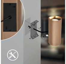 Montageanleitung für eine geriffelte Wandleuchte mit Wandhalterung, Schrauben und Werkzeugsymbol.