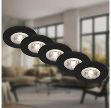 Fünf runde LED Einbaustrahler in moderner Optik vor einem unscharfen Wohnzimmerhintergrund.