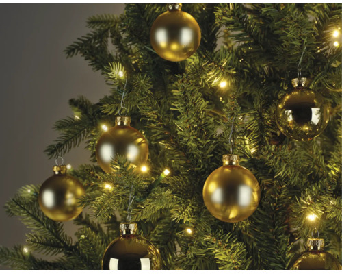 Weihnachtsbaum dekoriert mit goldfarbenen Christbaumkugeln in matt und glänzend sowie einer warmweißen Lichterkette.