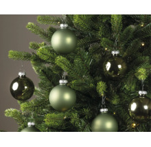 Weihnachtskugeln in verschiedenen Grüntönen, matt und glänzend, hängend an einem grünen Weihnachtsbaum.