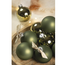 Grüne Weihnachtskugeln in matten und glänzenden Ausführungen mit silbernen Kappen und dekorativen Schleifen auf einem Holztablett.