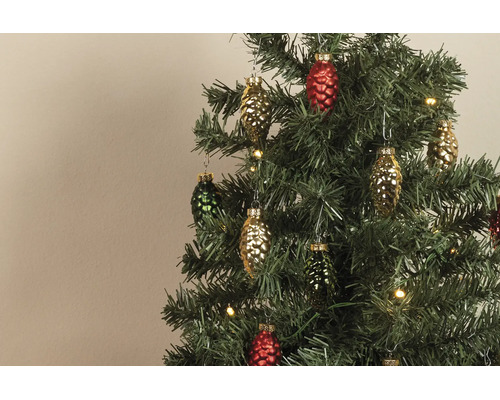 Farbige Glasanhänger in Zapfenform an einem künstlichen Weihnachtsbaum mit warmweißen Lichtern.