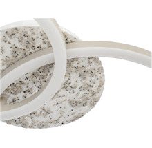 Moderne LED-Leuchte mit rundem Sockel in Steinoptik und geschwungenen Lichtbändern.