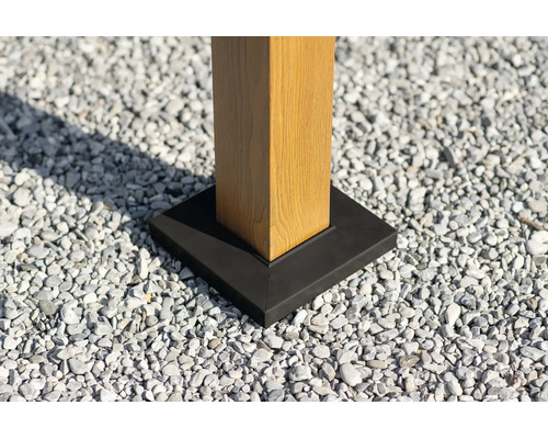 Quadratischer Pfostenfuß aus Metall an einem Holzpfosten auf Kies.
